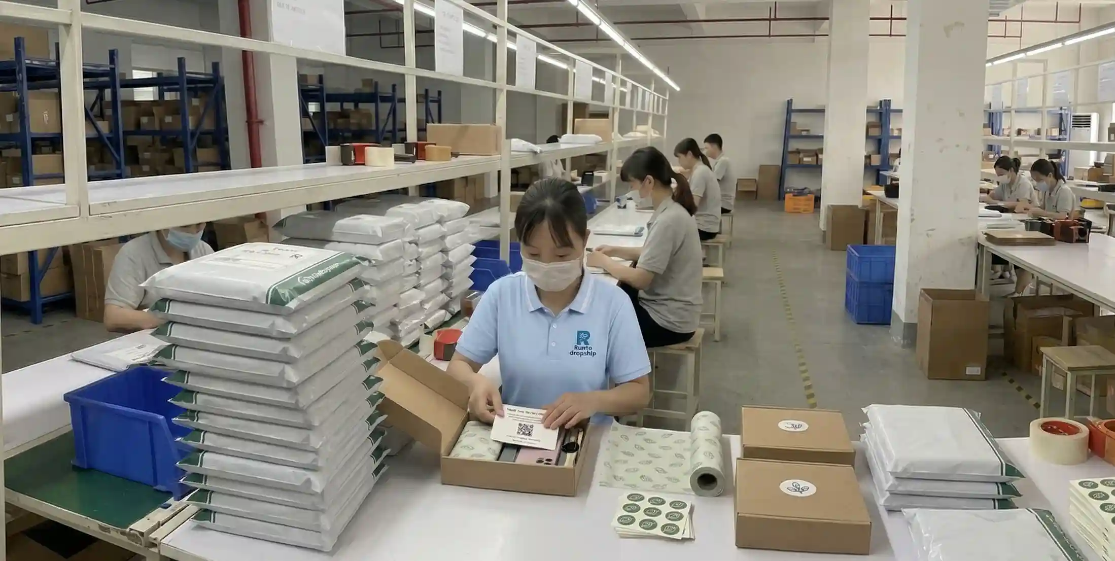 Warehouse staff adding a thank-you card and branded packaging insert to a private label order in a China dropshipping warehouse