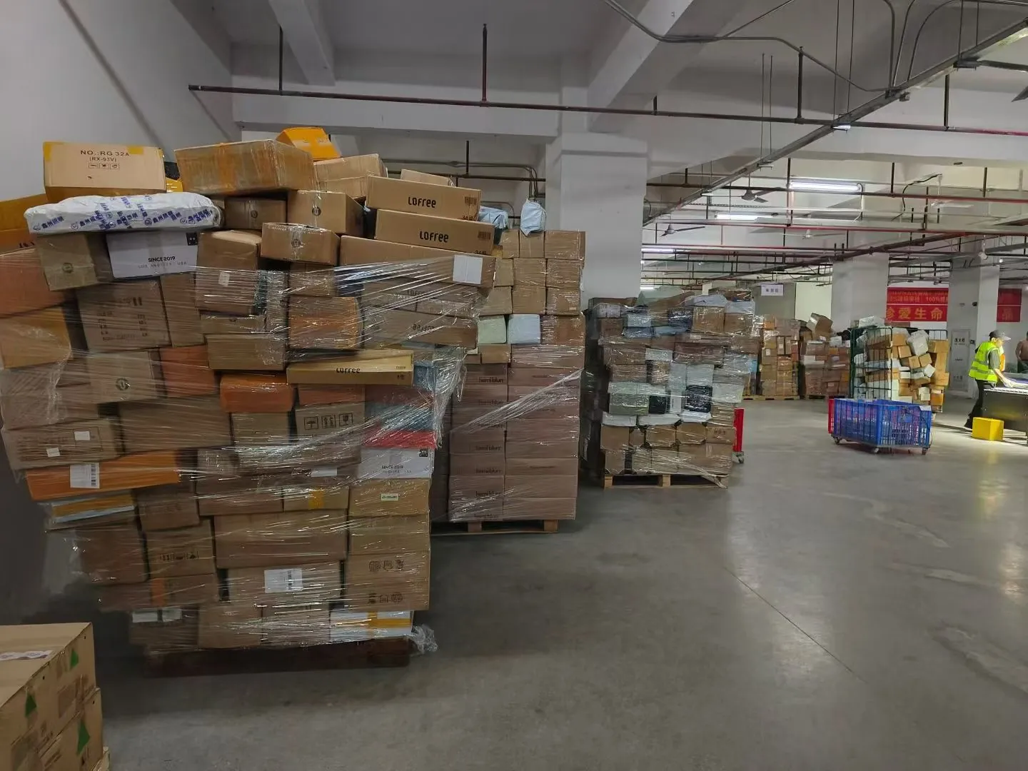 A wide warehouse hall with pallets stacked high with cardboard cartons